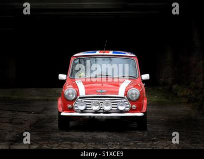 Un classico British Mini Cooper automobile nel colore rosso brillante verniciatura con grandi luci antinebbia e un raccordo MARTINETTO TETTO Foto Stock