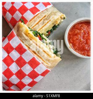 La colazione burrito sono avvolti in bianco e rosso la carta a quadretti e servita con un piattino di salsa al caffè Montana in San Antonio Tlayacapan. Foto Stock