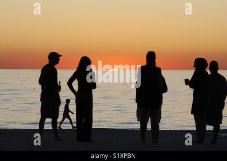 Beachgoers guardare il tramonto su Anna Maria Island, Florida. Foto Stock