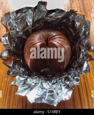 Mezza mangiata Terry al cioccolato di colore arancione. Foto Stock