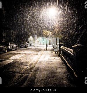La neve cade passato un lampione di notte Foto Stock