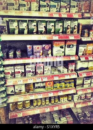 Avvia il farmacista, interno, ben rifornita ripiani con una varietà di farmaci OTC Foto Stock