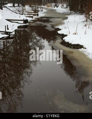 Scongelare in un piccolo ruscello. Lungo tutta la sponda sinistra del fiume, ci sono piccoli pontili. Presto, piccole imbarcazioni sono ormeggiate lì. Foto Stock