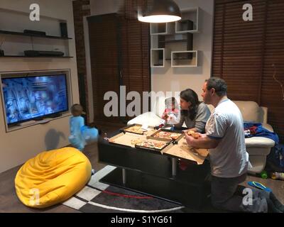 Famiglia mangiare la pizza a casa Foto Stock