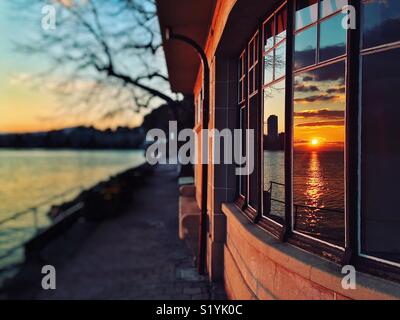 Tramonto sul lago di Ginevra riflessa nelle finestre di un edificio Art Deco Foto Stock