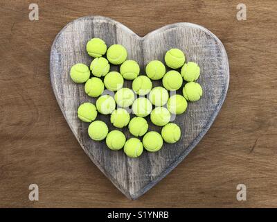 Amore mio dolce palle da tennis bon bons su un cuore di legno Foto Stock