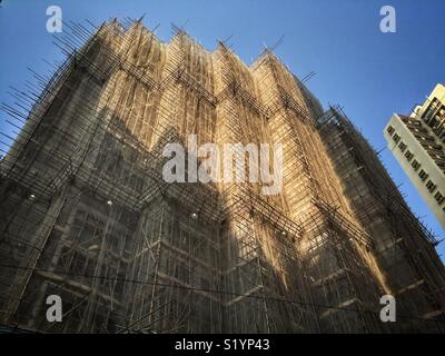 Un alto edificio residenziale di appartamenti coperti con bambù ponteggio a Wan Chai, Isola di Hong Kong Foto Stock