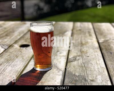 La pinta di birra ale sulla birra Tavolo da giardino Foto Stock