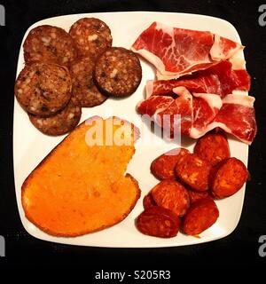 Salsicce di sangue, prosciutto, salsicce e pane tostato con lardo in Carniceria Ana, Sierra de Cadice, Andalusia, Spagna Foto Stock