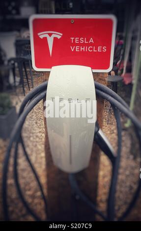 Una Tesla auto elettrica punto di carica con segno Foto Stock
