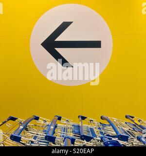 IKEA carrelli e segno di freccia - shopping in questo modo Foto Stock
