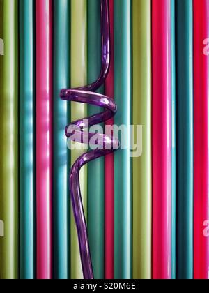 Multi-colore di cannucce di plastica con uno viola a spirale in paglia medio Foto Stock