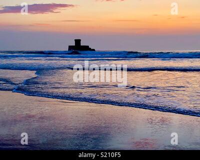 Tramonto sulla bellissima isola di canale di Jersey. La Torre Di Rocco in St Ouens Bay. Foto Stock