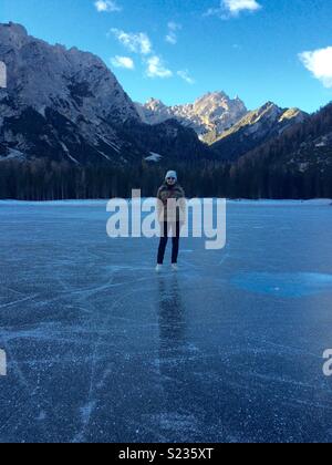 Pattinare sulla superficie ghiacciata del lago di Braies, Italia. Foto Stock