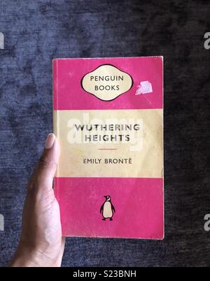 Una mano che tiene Wuthering Heights paperback da Emily Brontë Foto Stock