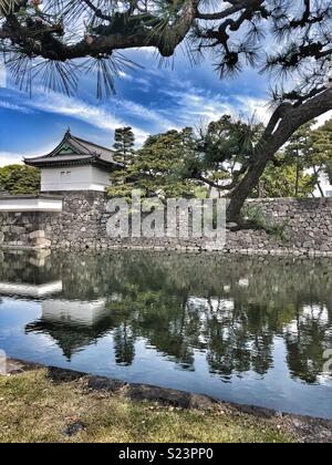 Muro di pietra e il fossato intorno al palazzo imperiale di Tokyo. Foto Stock