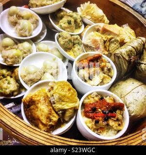Tradizionale cucina Cantonese dim sum, per la vendita come cibo da asporto in una strada del mercato di Yuen Long, Nuovi Territori di Hong Kong Foto Stock