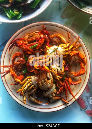 Tutta i granchi di acqua dolce fritto servito con peperoncino e erba cipollina in un maso di montagna soggiornare appena fuori di Yichang, Cina. Foto Stock