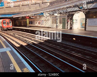 Treno della District line tirando in Bow Road tube station Foto Stock