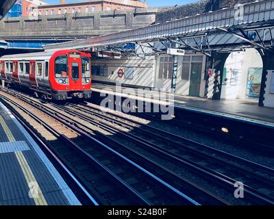 Treno della District line tirando in Bow Road tube station Foto Stock