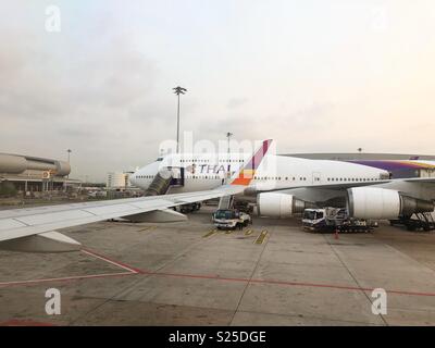 Sorriso tailandese A320-200 accanto alla Thai Airways Boeing 747-400 - Presa sul sorriso tailandese numero di volo CI168. Airbus A320-200 (HS-TXR) - 1 Marzo 2018 Foto Stock