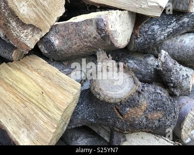 Un trito di essiccazione del legno fuori nel sole pronto per essere utilizzato in un bruciatore di registro Foto Stock