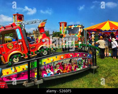 Giostre, merry-go-round e di stallo laterale all'annuale Sherborne Castle Country Fair, Sherborne, Dorset, Inghilterra Foto Stock