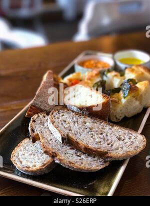 Pane appena sfornato su un tavolo con olio di oliva Foto Stock