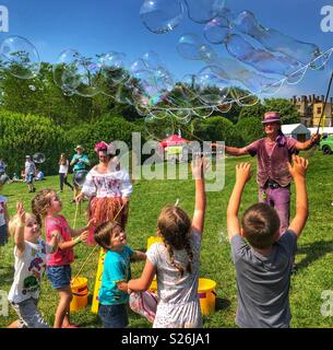 Bubbleman e bolla Faerie la creazione di bolle di sapone e bambini che cercano di pop, Sherborne Castle Country Fair, Sherborne, Dorset, Inghilterra Foto Stock