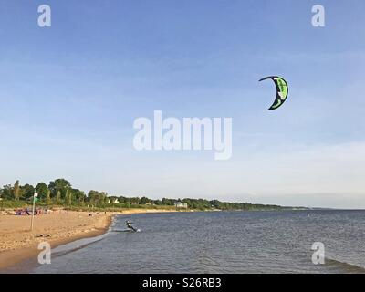 South Haven, Michigan, Stati Uniti d'America - 8 Giugno 2018: uomo kite surf lungo la spiaggia di South Haven Michigan sul Lago Michigan con blue sky copia spazio. Foto Stock