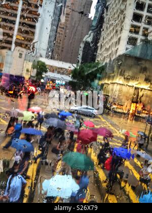 Attraversamento pedonale su Des Voeux Road, Central, Hong Kong, visto attraverso la finestra ad umido di un tram Foto Stock