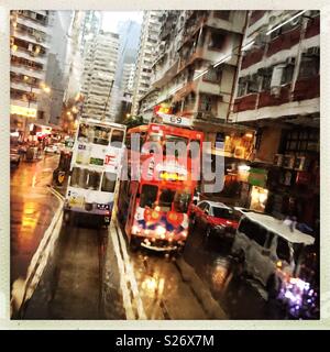 I tram sulla strada Johnston, Wan Chai, Isola di Hong Kong, visto attraverso la finestra ad umido di un tram Foto Stock