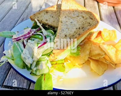 Panino al formaggio, sul pane marrone lato con insalata e patatine Foto Stock