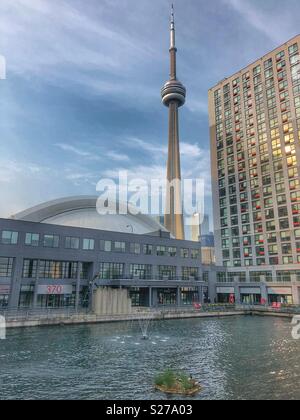 Una vista della CN Tower e il Rogers Centre da Peter Street Basin Parco nel quartiere Harbourfront. Foto Stock