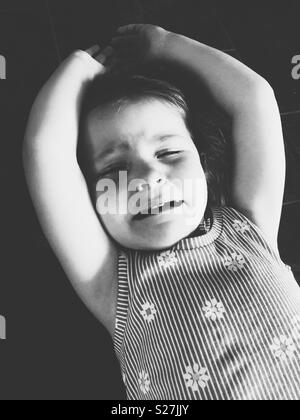 B&W immagine di pianto toddler girl avente una temper tantrum sul pavimento Foto Stock