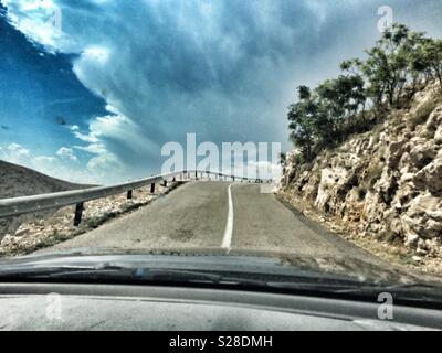 La guida su una strada verso la tempesta, Isola di Krk, Croazia. Foto Stock