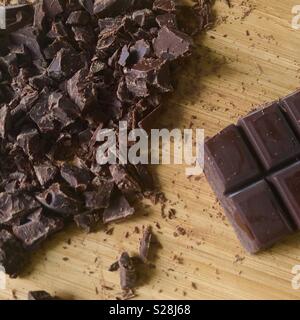 Cioccolato fondente pezzi su una tavola di bambù Foto Stock