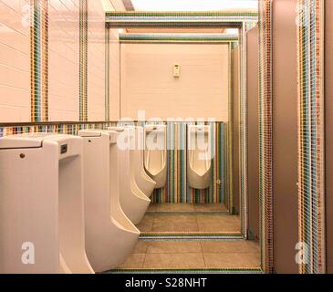 Fila di orinatoi nel concetto retrò toilette maschile con colorate piastrelle di ceramica sfondo Foto Stock