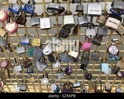 Molti blocchi che rappresentano gli amanti, gli amici e la famiglia bloccato su una ringhiera a ponte Foto Stock