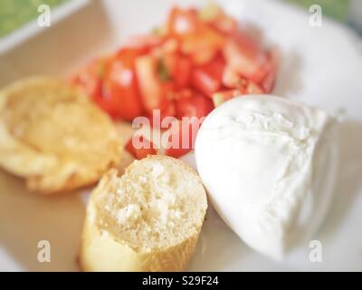 In casa caprese fatta con mozzarella, di pomodori tagliati a pezzi e fette di pane. Estate italiana cibo Foto Stock