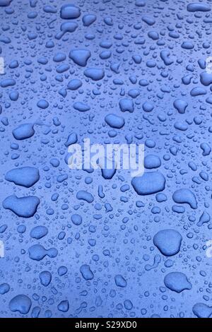 Le goccioline di acqua blu sulla superficie metallica Foto Stock