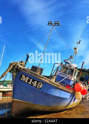 Barca da pesca nel porto di New Quay, West Wales, bassa marea. Foto Stock
