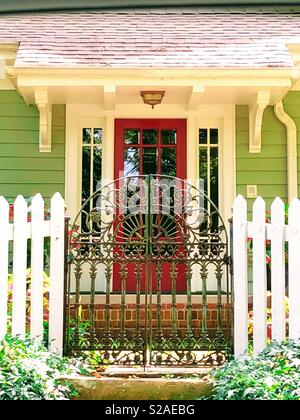 Cancello di ferro a white Picket Fence davanti la casa. Foto Stock