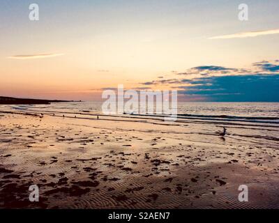 Tide andando fuori durante il periodo estivo il tramonto Foto Stock