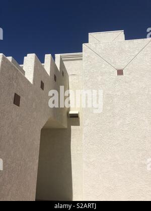 Dettagli architettonici di una parete in stucco con cielo blu sullo sfondo. Foto Stock