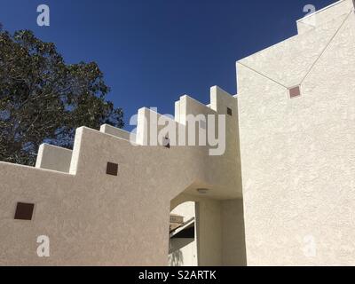 Dettagli architettonici di una parete in stucco con cielo blu sullo sfondo. Foto Stock