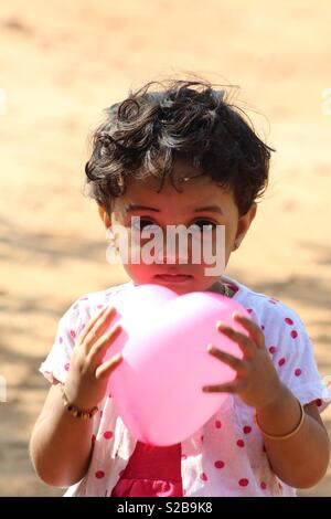 Carino Baby girl palloncino di contenimento Foto Stock