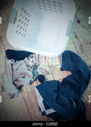Svuotare un cesto della biancheria con indumenti sporchi accanto ad esso. Da sopra Foto Stock