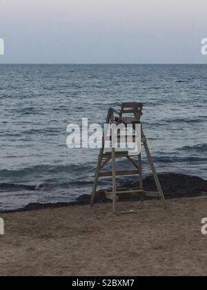 Svuotare bagnini sdraio in spiaggia al tramonto Foto Stock