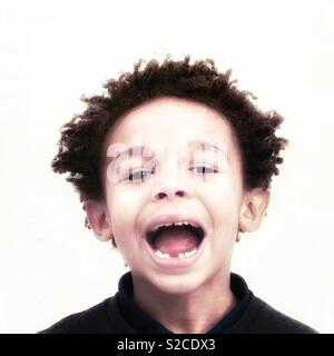 Un ragazzo si mette in mostra il suo divario nella sua dentatura. Foto Stock